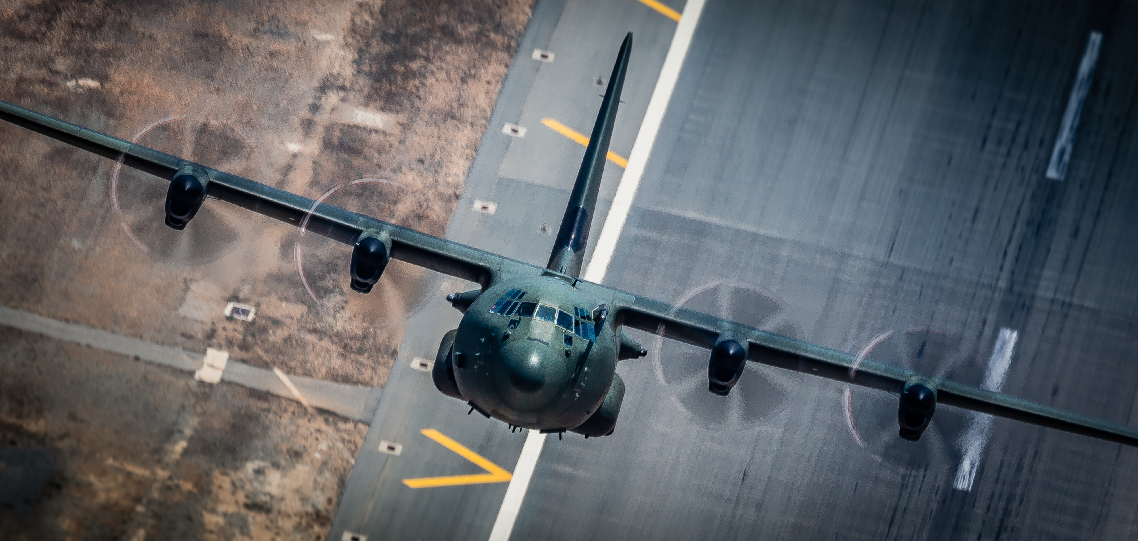 Aerial view of a C-130J as it flies upwards. 